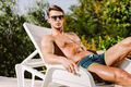 Photogenic muscular man in sunglasses relaxing on sunbed naked torso - PhotoDune Item for Sale