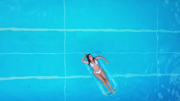 Pretty Girl Lies on an Air Mattress in the Swimming Pool