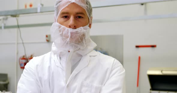 Butcher standing in meat shop with his arms crossed