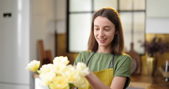 Woman Decorates Home Interior with a Bouquet of Fresh Flowers