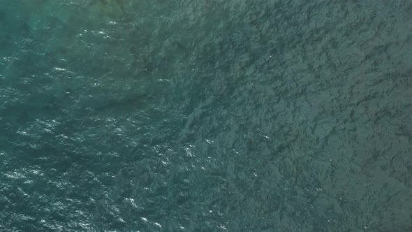 aerial drone overhead view flying up and away from waves water on lake superior revealing sunny shor