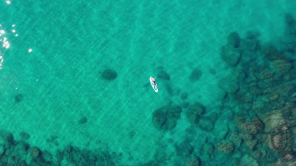 Tourist Floating With Surfboard In Turquoise Beach Of South Lake Tahoe In California, USA. Aerial Or