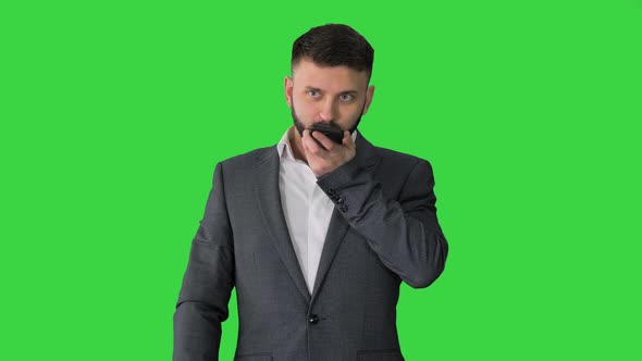 Turk Businessman Using Smartphone's Digital Voice Assistant on a Green Screen, Chroma Key.