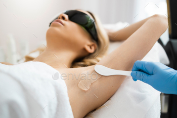 armpit area. Woman lying during laser hair removal procedure