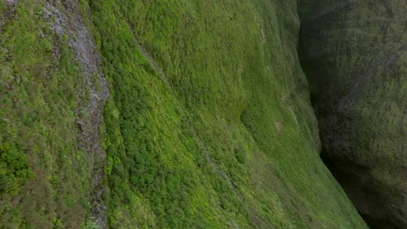 Aerial Footage of the Slope Covered with Bright Green Grass and Deep Narrow Cleft