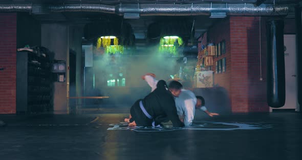 Young Fighter in a Kimono Makes a Capture of the Enemy and Inflicts a Painful Technique Working Out