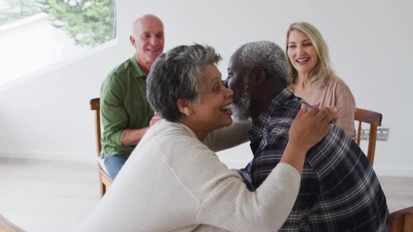 Two diverse senior couples sitting in circle having a therapy conversation at home