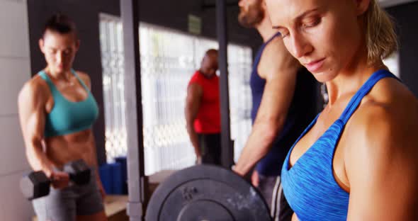 Beautiful fit woman exercising with dumbbell