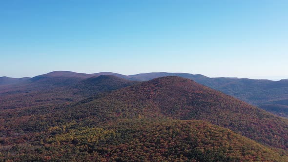 An aerial shot (dolly out) of Tibbet Knob and Great North Mountain in Autumn. The mountain range is