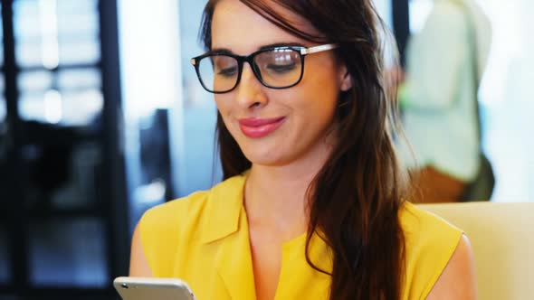 Female business executive using mobile phone