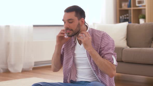 Man in Headphones Meditating in Lotus Pose at Home 