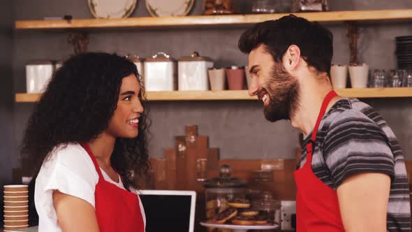 Waiter and waitress smiling in caf������������