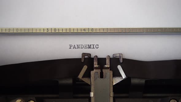 Typing word PANDEMIC on retro typewriter. Close up.