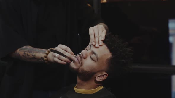 Hairdresser Shaving African American Man. 
