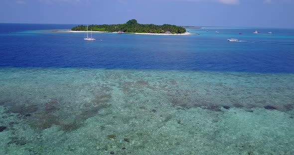 Tropical above copy space shot of a white sandy paradise beach and blue ocean background in vibrant 