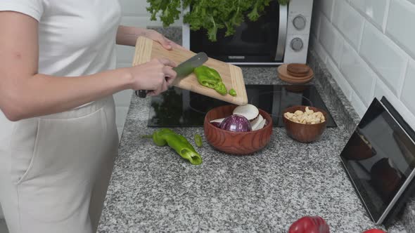 Housewife Is Getting Wooden Bowl In Kitchen Cupboard While Cooking