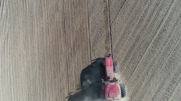 Countryside and Agriculture Farm Tractors Plow the Earth in Field Dust in the Field View From Height