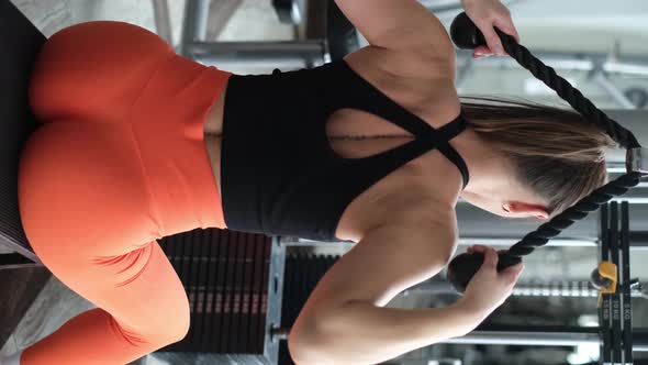 Vertical Video Woman Trains the Back Muscles in the Gym She Pumps the Main Muscle Groups