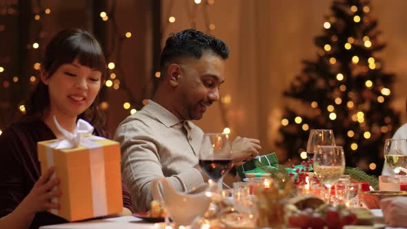 Friends Having Christmas Feast and Giving Presents