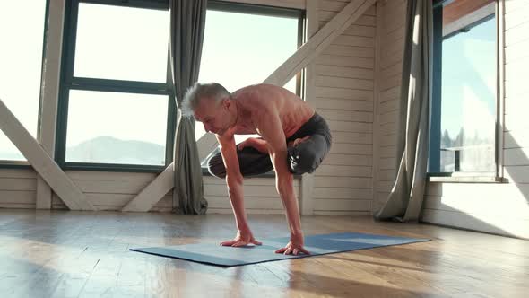 Mature Man Amongst Doing Power Yoga Exercises.