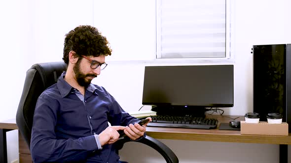 Latin man making a call in office at home. Steady shooting. Home office subject.