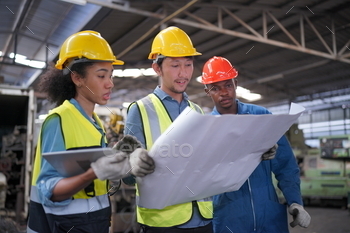  Worker Wearing Safety Uniform, Goggles and Hard Hat. In the Background Unfocused Large Industrial Factory