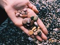 Multicolored sea pebbles on an open palm - PhotoDune Item for Sale
