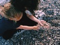 Family on the beach - mother and little girl with curly hair collecting pebbles - PhotoDune Item for Sale
