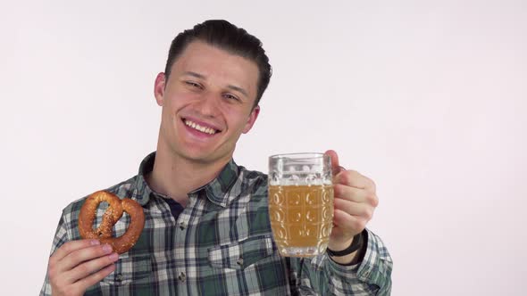 Handsome Cheerful Man Holding Out Delicious Beer in a Mug To the Camera