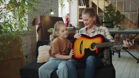 A Girl Tells Her Mother That She Does Not Want to Learn to Play the Guitar and Pushes the Instrument