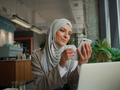 Muslim woman on remote working, online education or video conversation in caffe - PhotoDune Item for Sale