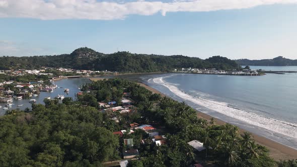 The port city of Quepos, Costa Rica on a sunny day viewed from Isla Damas. Ascending aerial shot