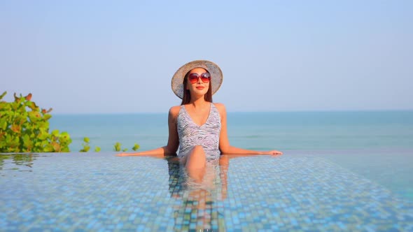 Young asian woman enjoy around outdoor swimming pool for leisure