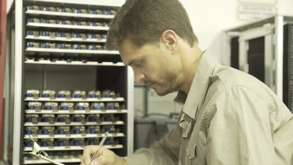 Electrical engineer working, turning to smile cheerfully at camera