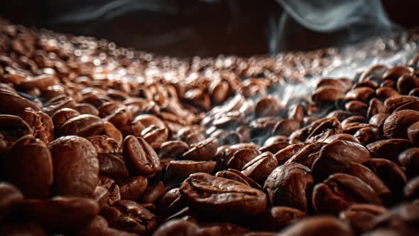 Close Up of Seeds of Coffee. Fragrant Coffee Beans Are Roasted Smoke Comes From Coffee Beans.