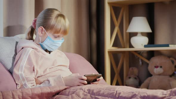 Girl in a Gauze Bandage Plays on a Smartphone