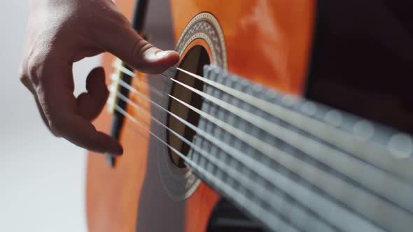 Closeup Fingers of Male Musician Playing on Strings an Acoustic Guitar