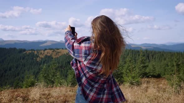 Female Hiker Taking Picture on Smartphone During Summer Hike in Mountains