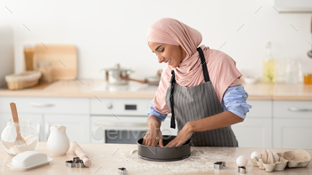 Happy Housewife. Young Islamic Lady In Hijab And Apron Baking At Home