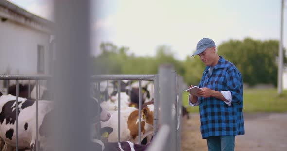 Farmer Gesturing While Writing on Clipboard Against Barn