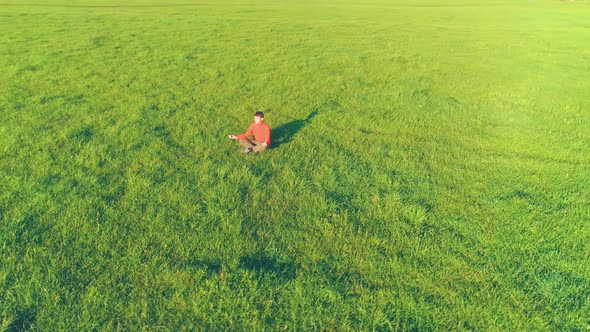 Low Altitude Radial Flight Over Sport Yoga Man at Perfect Green Grass