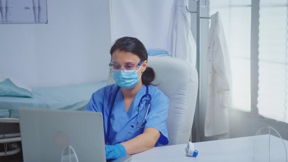 Nurse Typing on Laptop Wearing Medical Gloves