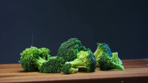 Fresh Green Broccoli Sprinkled with Salt Lying on Board