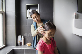 Mother Grooming Daughter In Bathroom