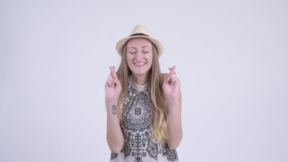 Portrait of Happy Blonde Tourist Woman Wishing with Fingers Crossed