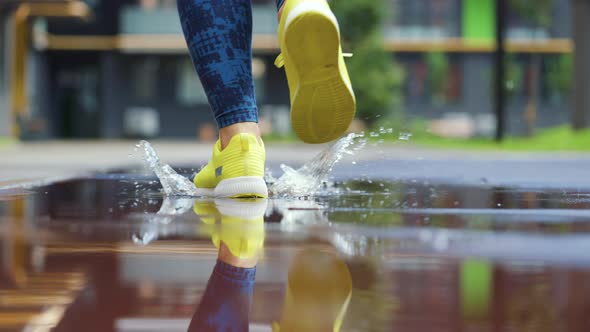Female Sports Woman Jogging Outdoors Stepping Into Puddle