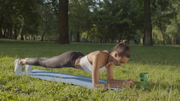 Woman Doing Planks Exercising Outdoors in Morning