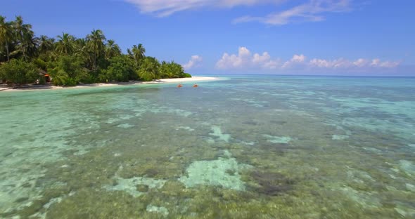 Aerial drone view of a man and woman couple kayaking around a tropical island