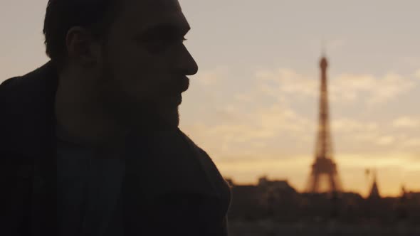 Close-up Sunset Portrait of Thoughtful European Young Man Looking Right at Paris Eiffel Tower Sky