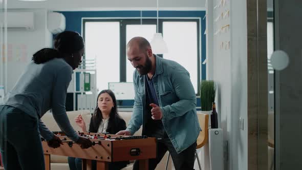 Multi Ethnic Colleagues Enjoying Play at Foosball Table